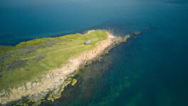 An aerial view of a small island with a lighthouse. mercedes ln2 1124af expedition truck
