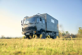 A truck is parked in a field with grass. mercedes ln2 1124af expedition truck